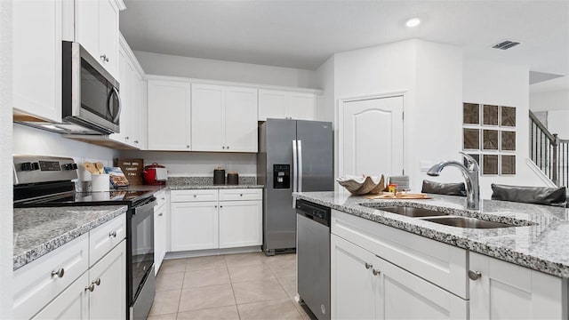 kitchen featuring visible vents, appliances with stainless steel finishes, white cabinets, and a sink