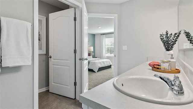 ensuite bathroom with double vanity, tile patterned flooring, ensuite bath, and a sink