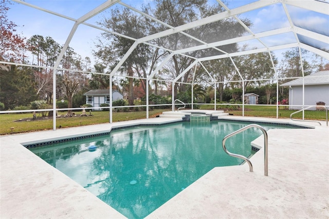 view of swimming pool featuring a lanai, a shed, a pool with connected hot tub, and an outbuilding