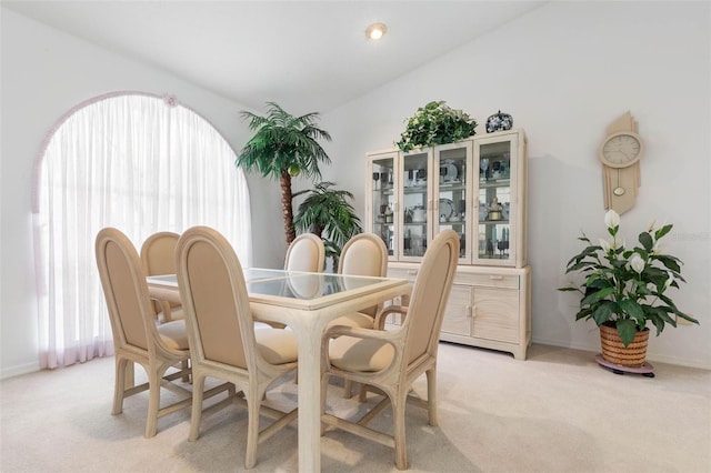 dining area featuring light carpet and baseboards