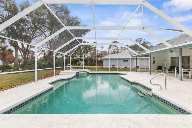 view of pool with glass enclosure, a patio area, a pool with connected hot tub, and a ceiling fan