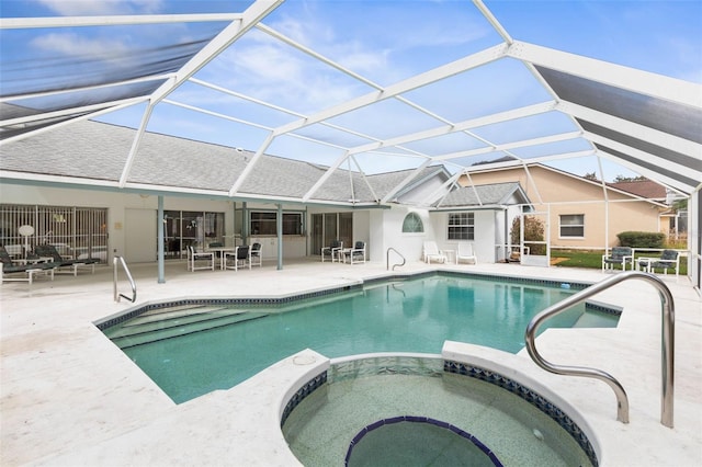 view of swimming pool with a pool with connected hot tub, glass enclosure, and a patio