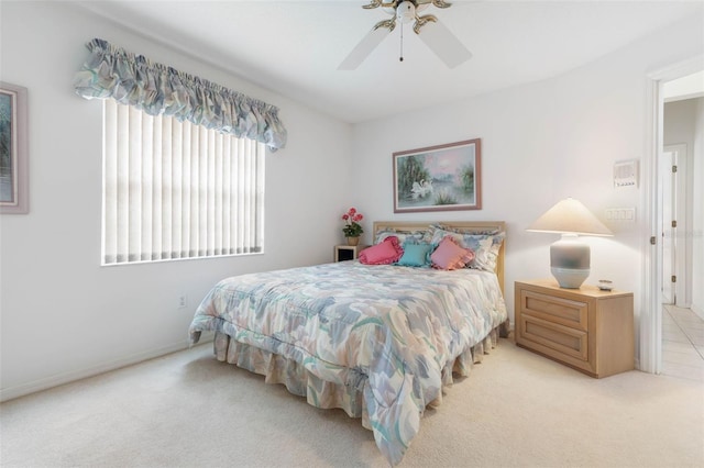 bedroom with a ceiling fan and light colored carpet