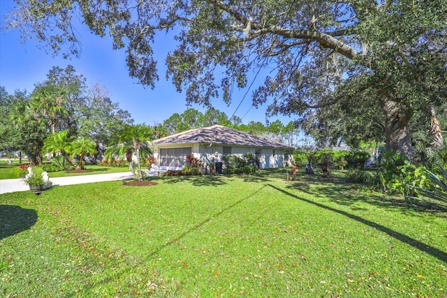 view of yard featuring driveway and a garage