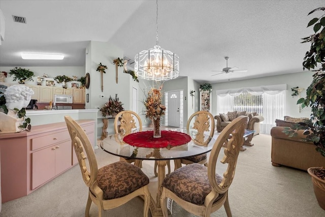 dining space featuring light colored carpet, visible vents, a textured ceiling, and an inviting chandelier