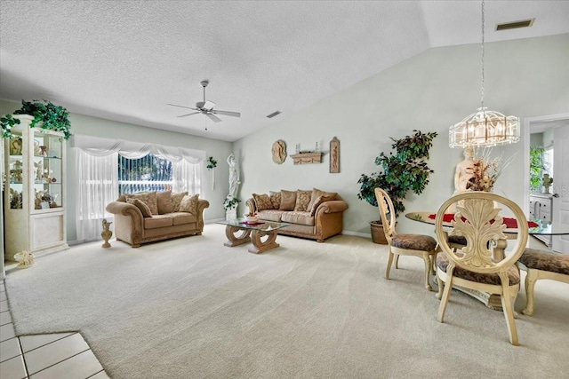 living room with lofted ceiling, ceiling fan with notable chandelier, visible vents, and light colored carpet