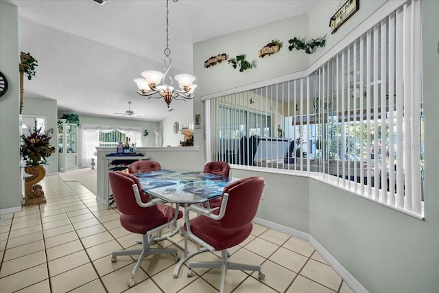 dining space with light tile patterned flooring, a textured ceiling, and baseboards