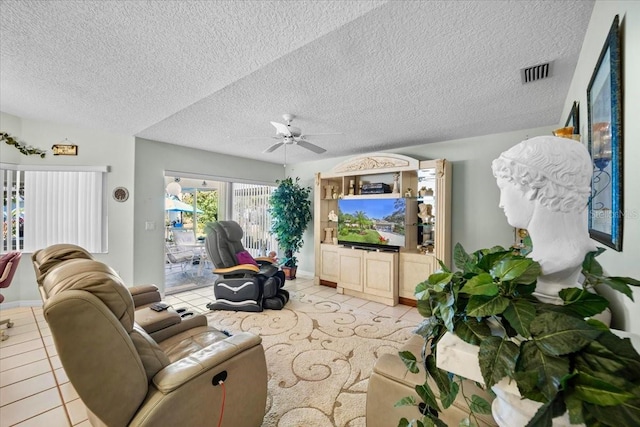 living area featuring a ceiling fan, visible vents, a textured ceiling, and light tile patterned floors