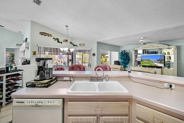 kitchen featuring light countertops, light brown cabinetry, open floor plan, a sink, and dishwasher