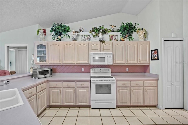 kitchen with lofted ceiling, light countertops, white appliances, and light tile patterned flooring