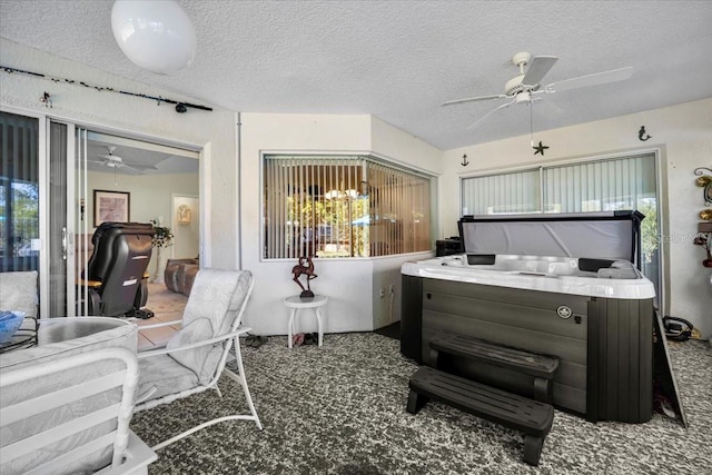 carpeted bedroom with a textured ceiling, multiple windows, and a ceiling fan