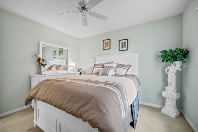 bedroom with a ceiling fan, light colored carpet, and baseboards