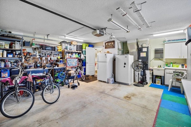 garage featuring a garage door opener, a sink, and freestanding refrigerator