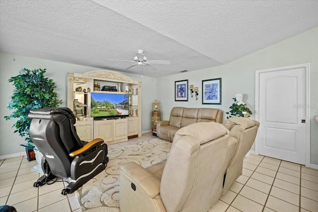 living area featuring baseboards, a ceiling fan, a textured ceiling, and light tile patterned flooring