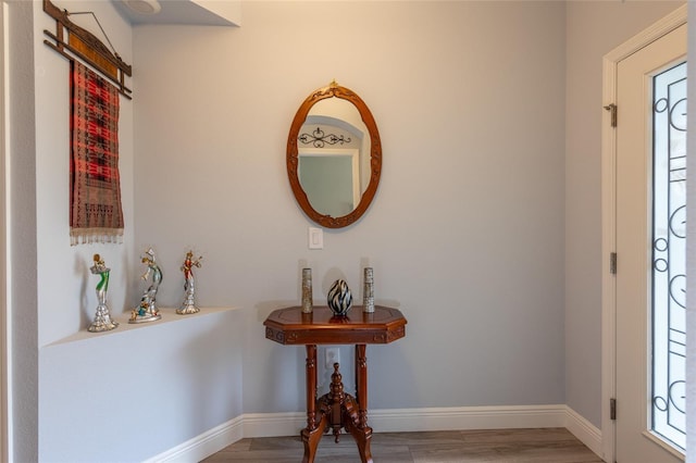 foyer entrance with light wood-style flooring and baseboards