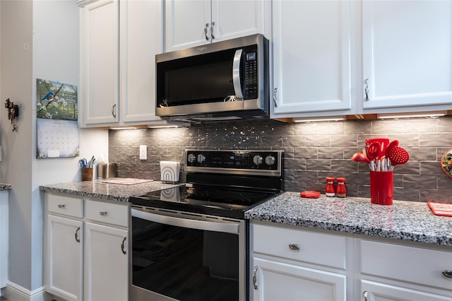 kitchen with stainless steel appliances, white cabinetry, light stone counters, and decorative backsplash