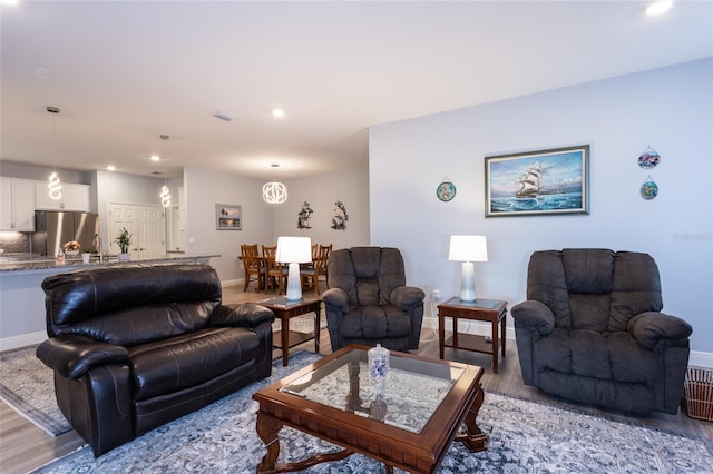 living area featuring light wood-type flooring, baseboards, and recessed lighting