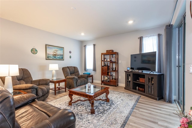 living area with light wood-style floors, baseboards, and recessed lighting