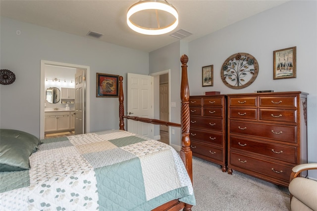 bedroom with ensuite bath, visible vents, a sink, and light colored carpet