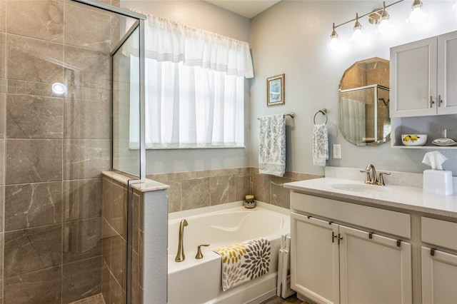 bathroom featuring a garden tub, vanity, and a shower stall