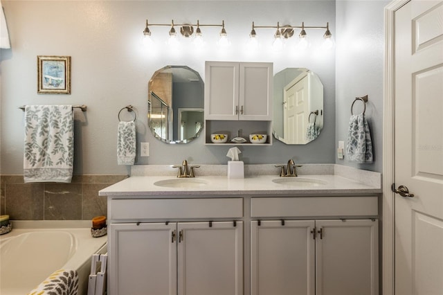 bathroom featuring a bath, double vanity, and a sink