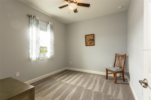 sitting room featuring a ceiling fan, carpet flooring, and baseboards