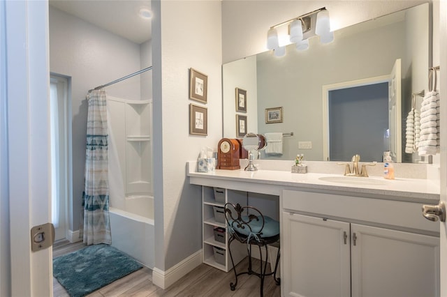 bathroom featuring shower / tub combo, wood finished floors, vanity, and baseboards