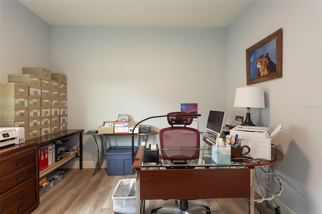 office space with light wood-style flooring and baseboards