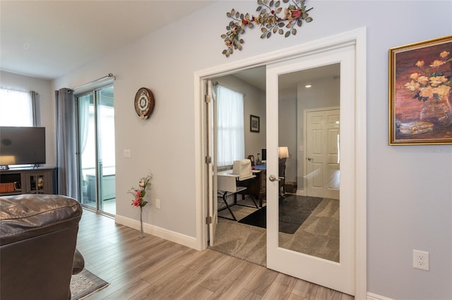 living room featuring light wood-style floors, french doors, and baseboards