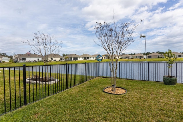 view of yard with a residential view and a water view