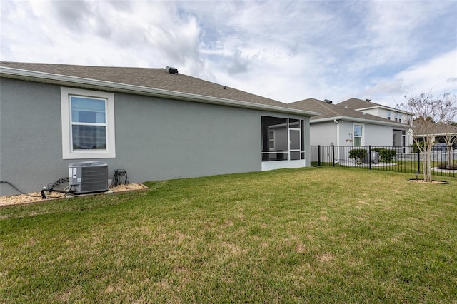 rear view of house with cooling unit, a shingled roof, fence, a yard, and stucco siding