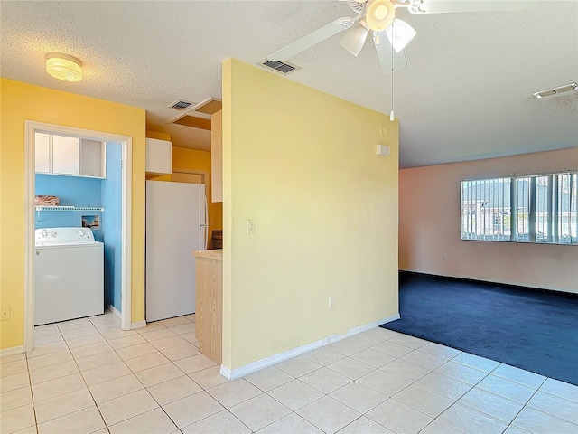 empty room with light colored carpet, washer / clothes dryer, visible vents, and light tile patterned flooring