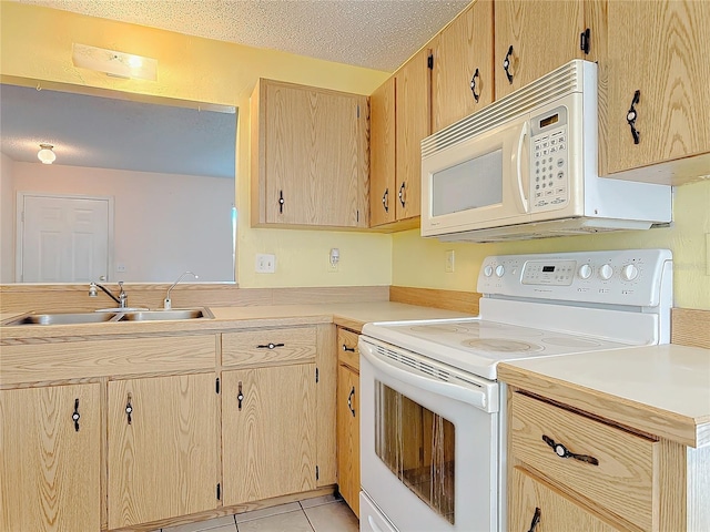 kitchen with white appliances, light tile patterned floors, light countertops, a textured ceiling, and a sink