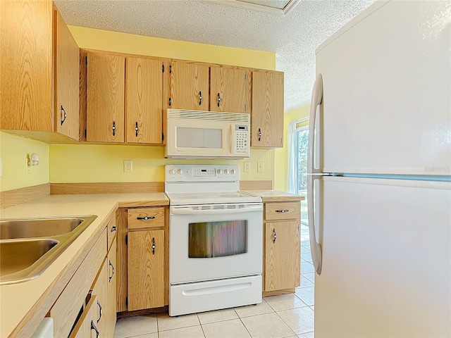 kitchen featuring light tile patterned floors, a textured ceiling, white appliances, a sink, and light countertops