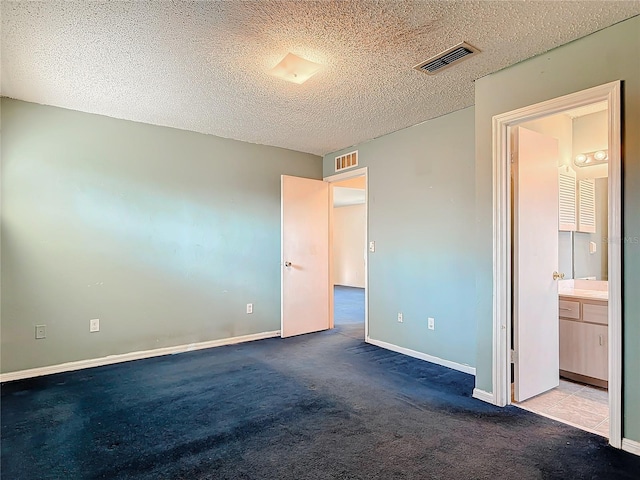 unfurnished bedroom featuring carpet floors, visible vents, a textured ceiling, and baseboards