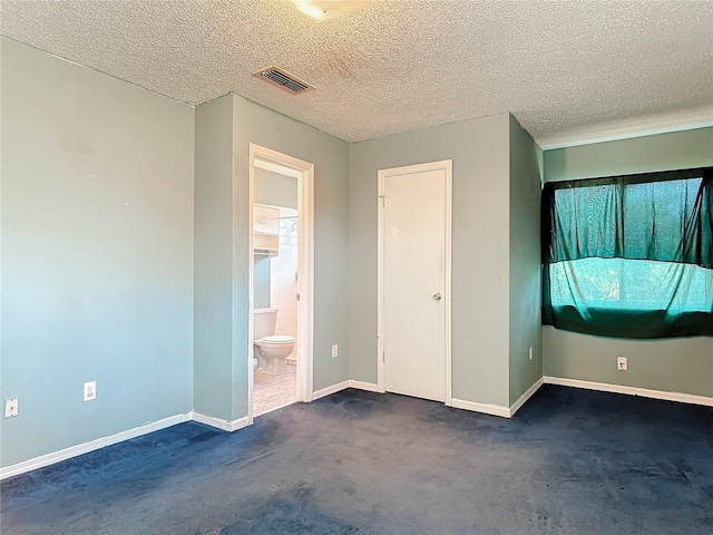 unfurnished bedroom with baseboards, visible vents, a textured ceiling, and ensuite bathroom