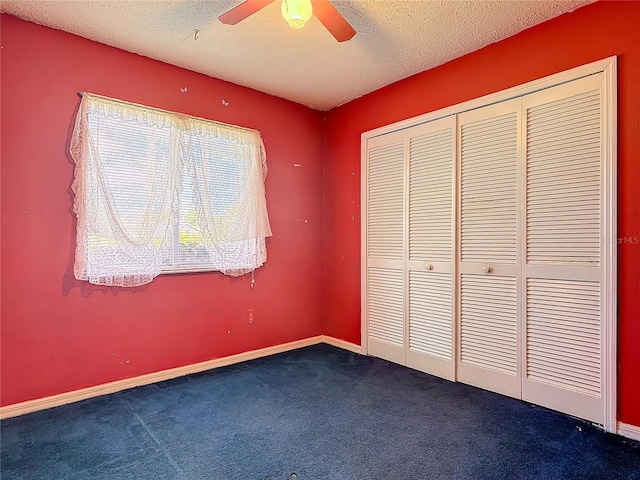 unfurnished bedroom featuring a textured ceiling, ceiling fan, carpet flooring, baseboards, and a closet