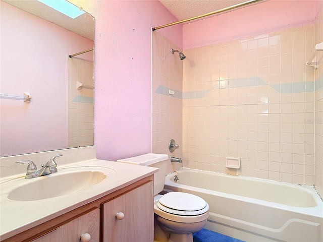 bathroom featuring a textured ceiling, bathtub / shower combination, toilet, a skylight, and vanity