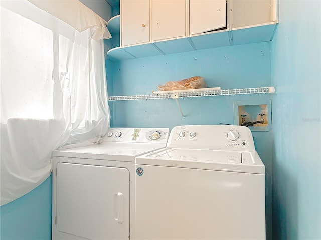 washroom featuring independent washer and dryer and cabinet space