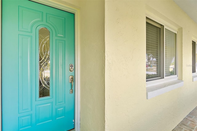 entrance to property featuring stucco siding