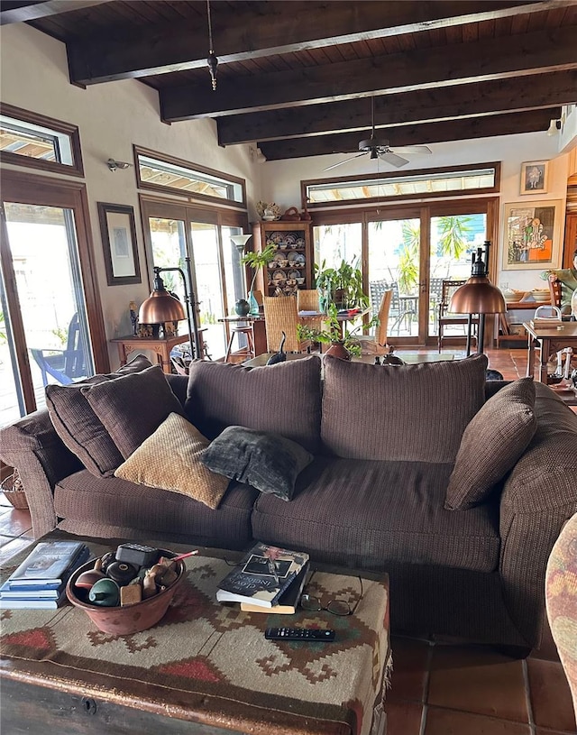 living area with a healthy amount of sunlight, wooden ceiling, ceiling fan, and beam ceiling