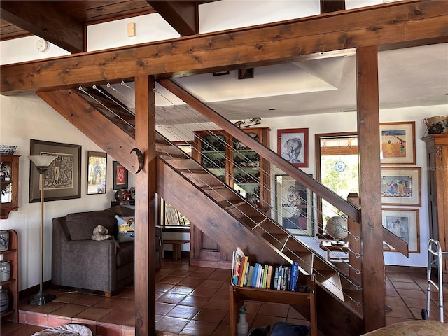 staircase with beamed ceiling and tile patterned flooring