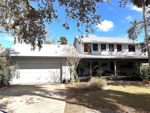 view of front of property with concrete driveway, metal roof, and an attached garage