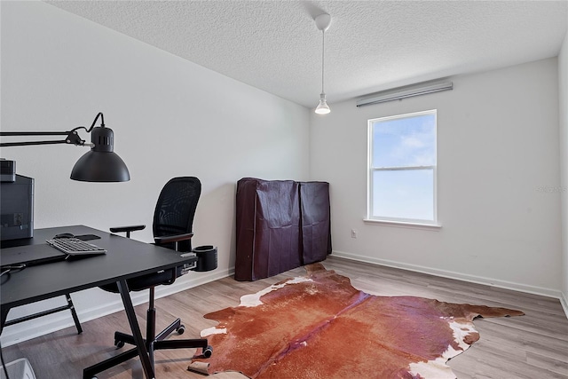 office space with a textured ceiling, baseboards, and wood finished floors