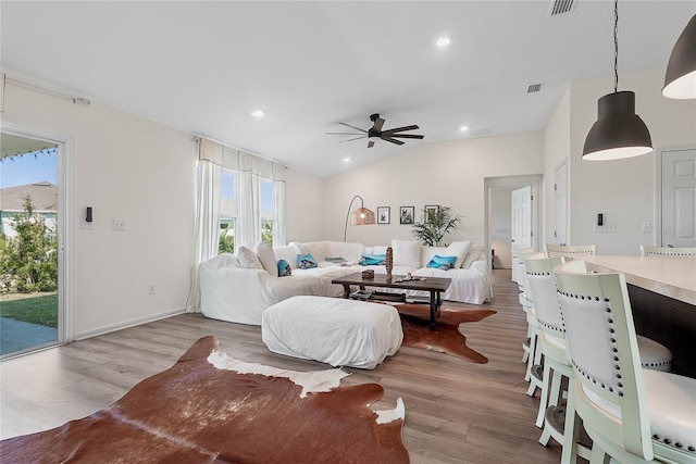 living area with lofted ceiling, visible vents, wood finished floors, and recessed lighting