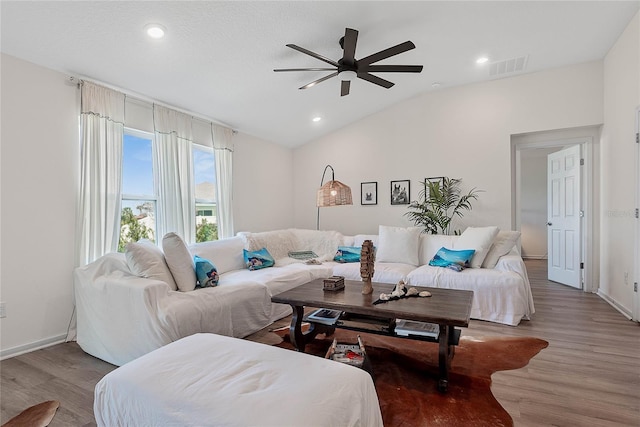 living area with lofted ceiling, visible vents, wood finished floors, and recessed lighting