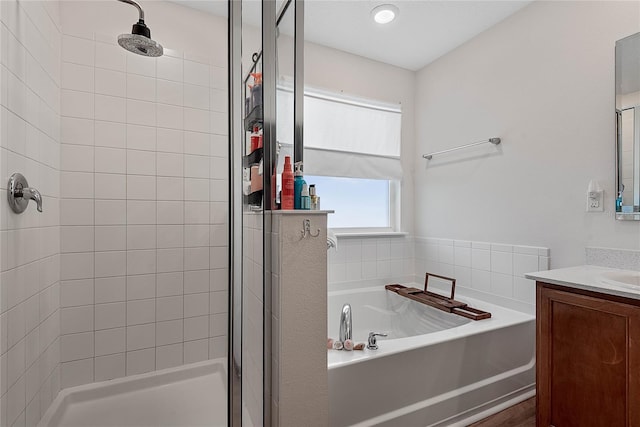 bathroom with a garden tub, a shower stall, and vanity