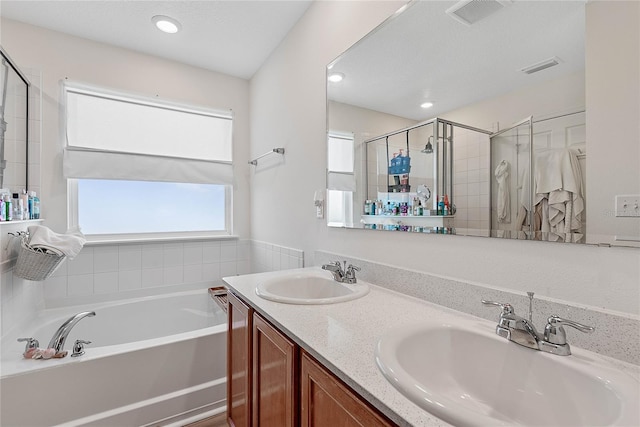 bathroom with a stall shower, visible vents, a sink, and a bath