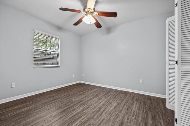 unfurnished bedroom with a closet, dark wood finished floors, a ceiling fan, and baseboards