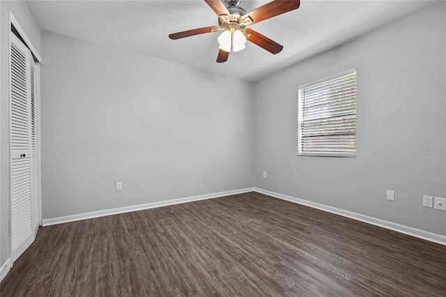 unfurnished bedroom with dark wood-style flooring, a closet, ceiling fan, and baseboards